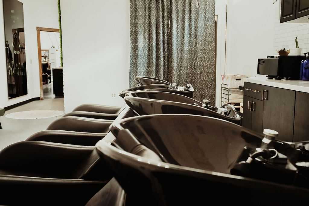 Row of empty salon hair wash stations in modern setting.